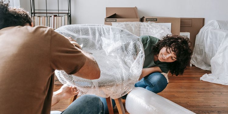 a man and woman wrapping their chair for storage