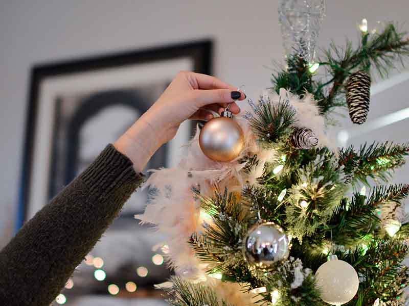 Woman taking ornaments off tree
