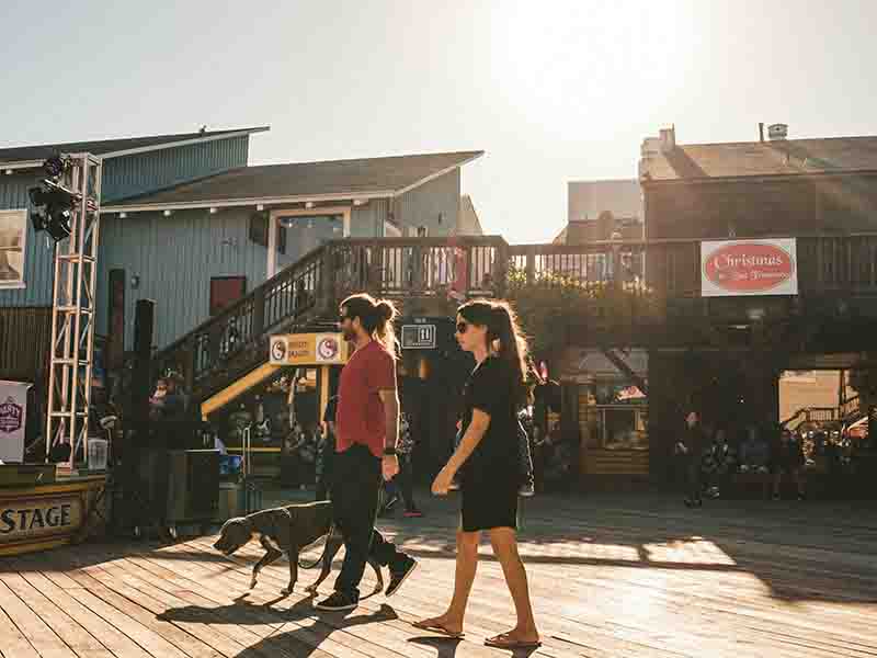 Man and woman walking dog in San Francisco shopping center
