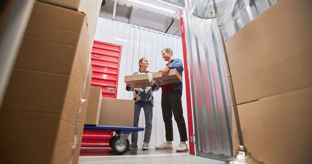 man and woman with boxes in a storage unit