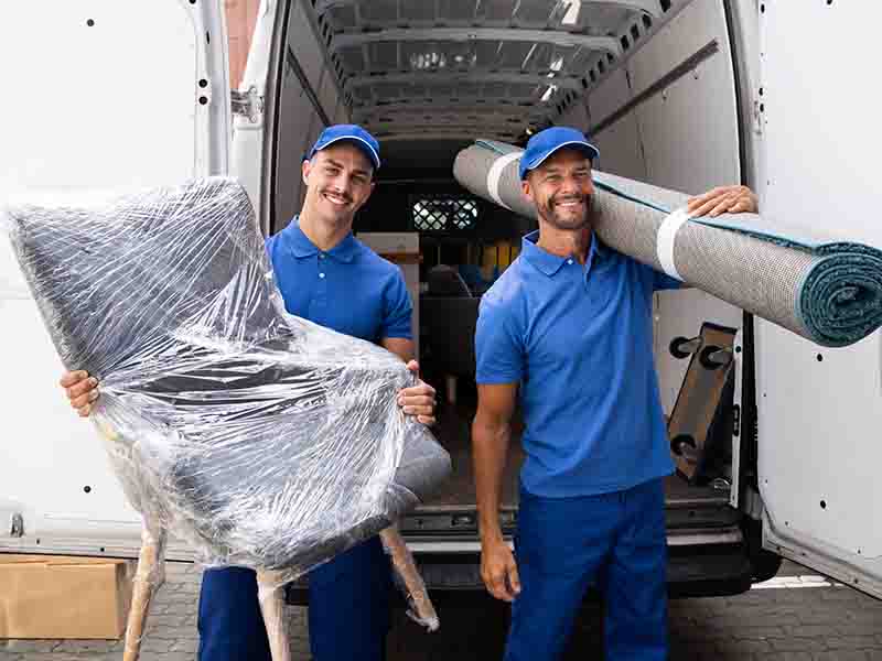 Movers carrying furniture and rug