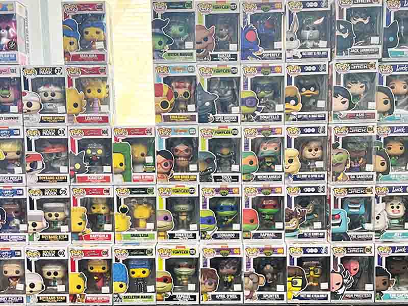 Funko Pop in boxes stacked against a glass wall.