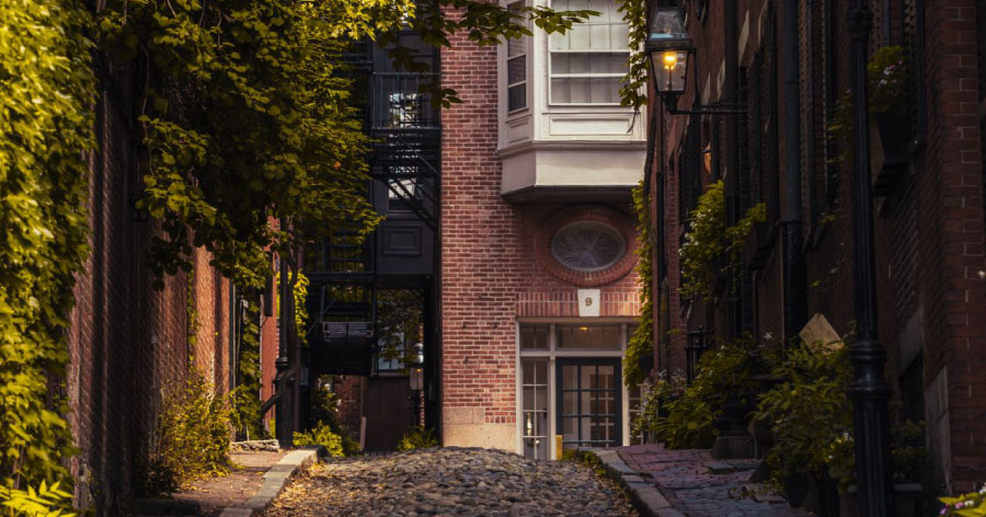 View of historic brick buildings on Acorn Street in Beacon Hill, one of the best Boston neighborhoods for historic architecture.